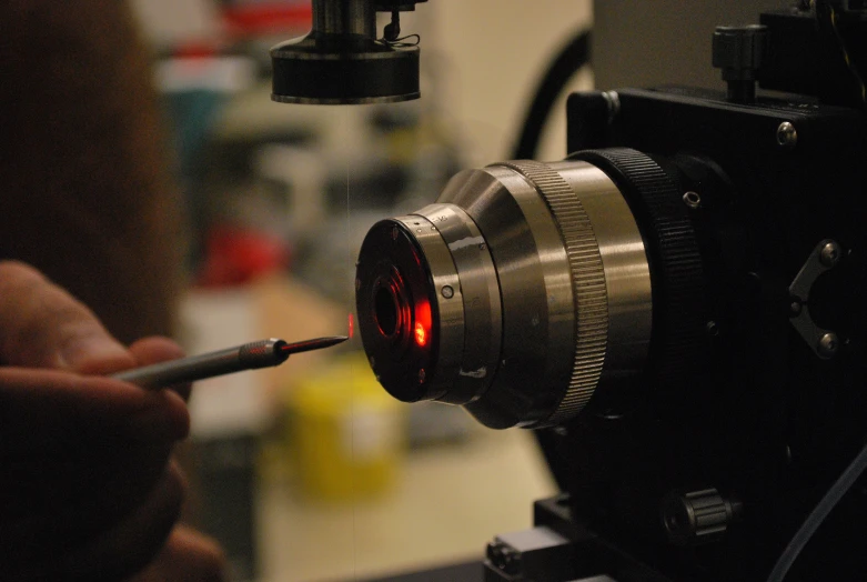 a person holding a camera with its lens