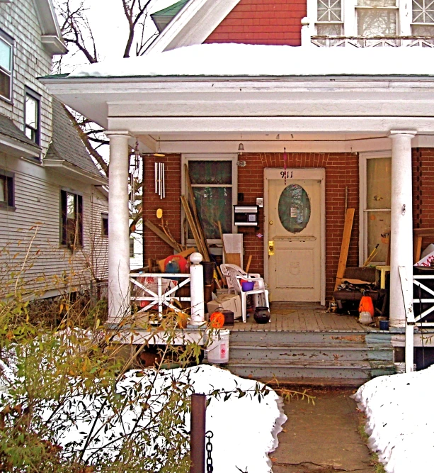 a porch and front of the house covered in snow