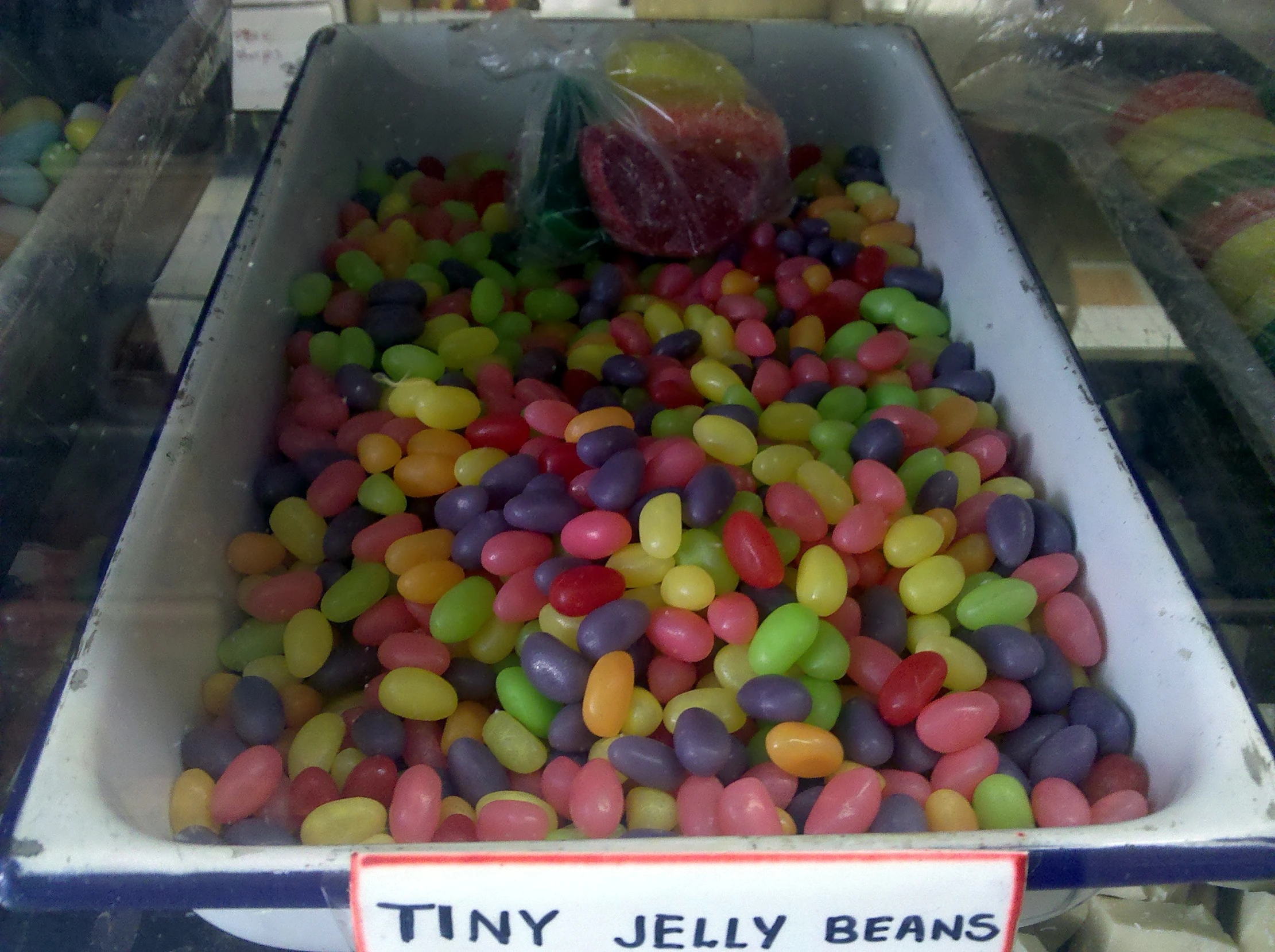 a large bin filled with candy chips sitting next to a sign