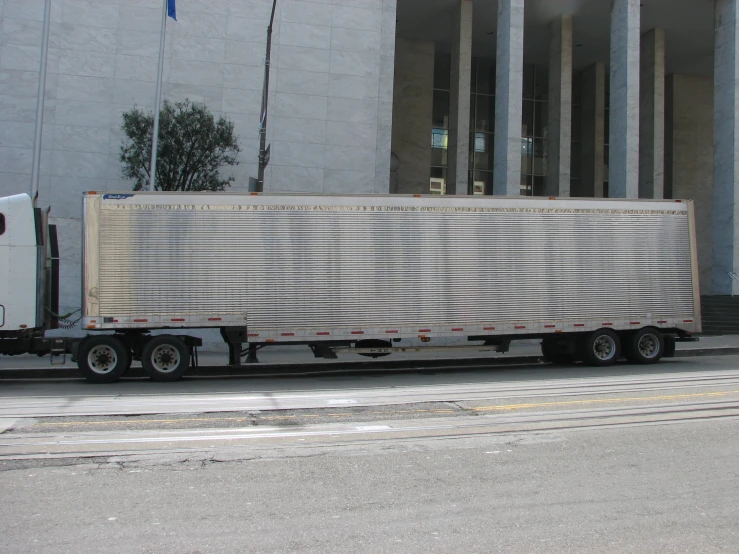 a semi truck is parked outside an office building