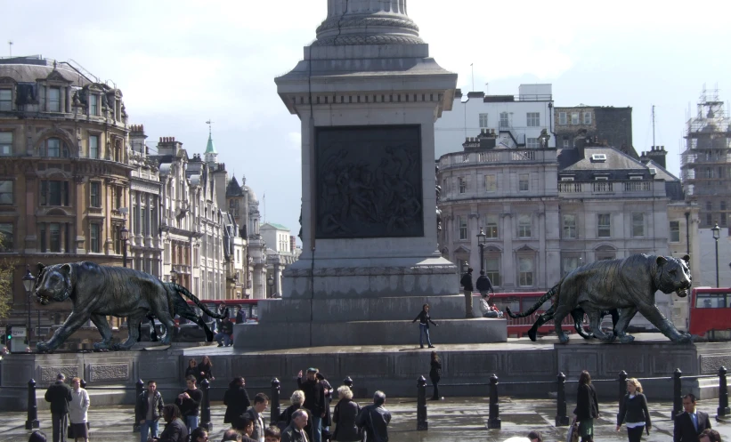 there are many people walking near this statue