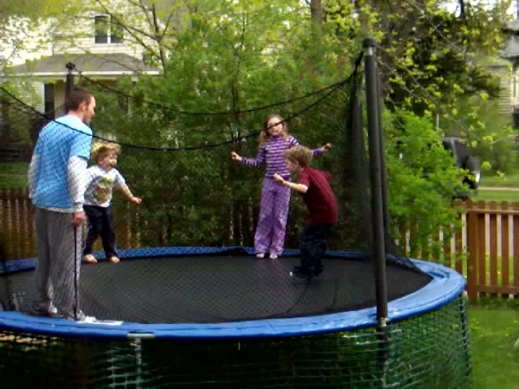 the children are standing on the trampoline