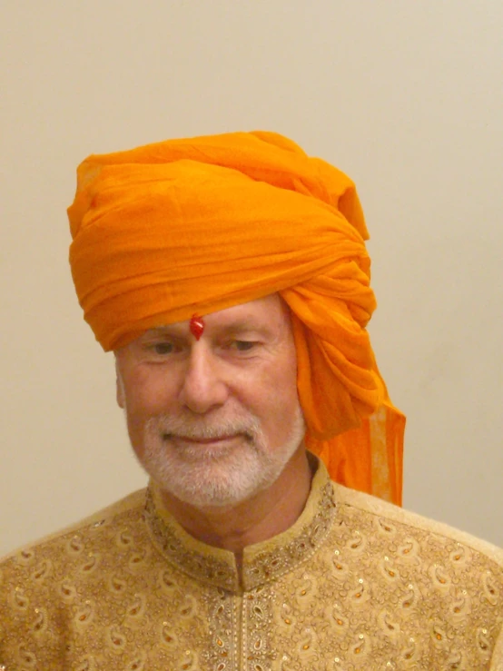 an indian man in orange clothing and a yellow turban