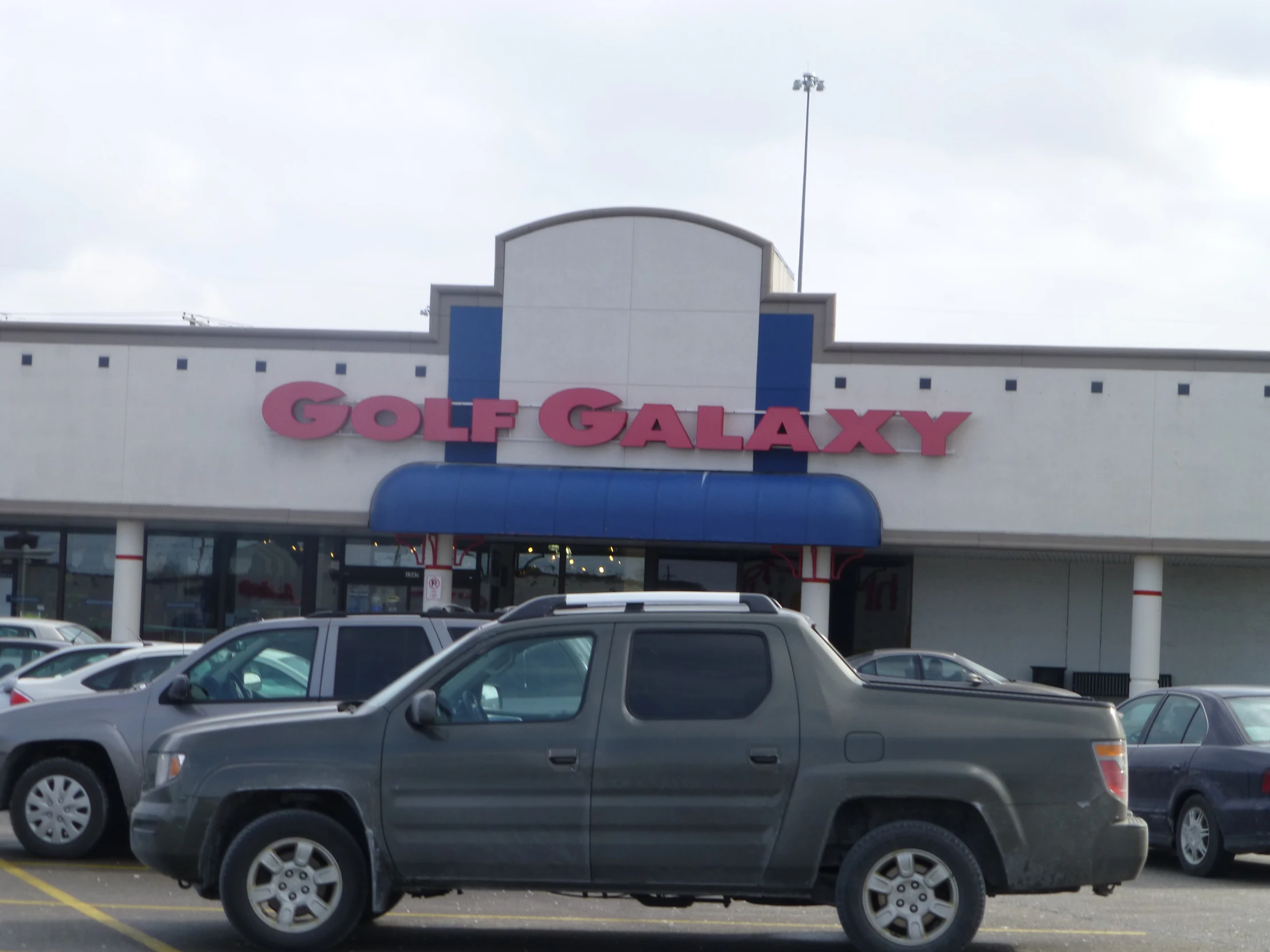 a large silver pickup truck parked in front of a store