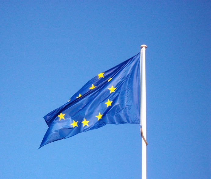 the eu flag flies high against a clear blue sky