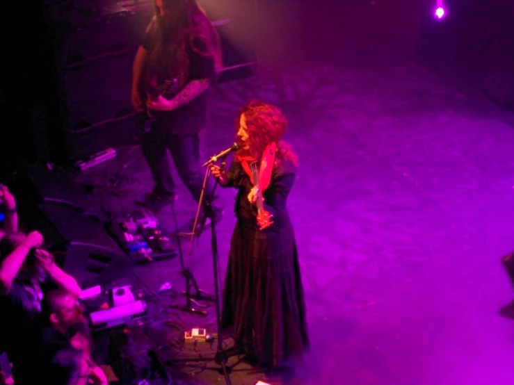 a woman standing on stage holding a microphone