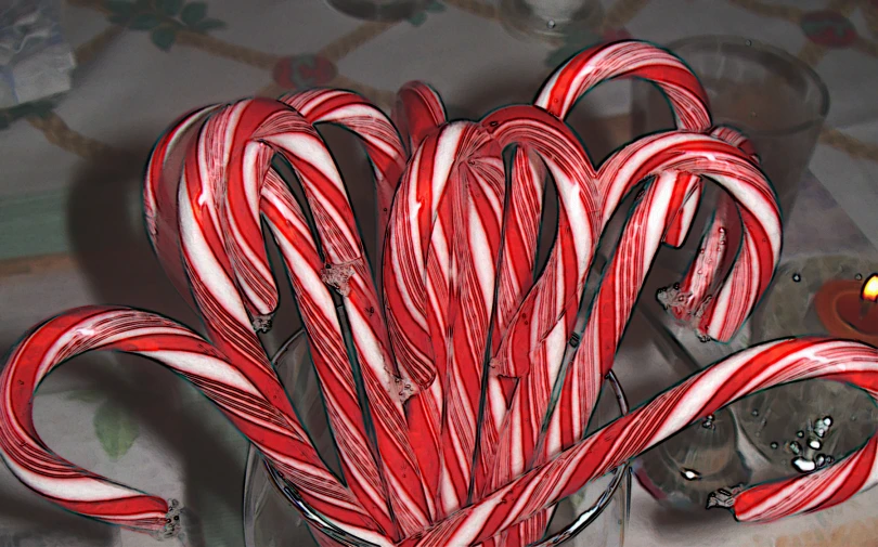 a can filled with candy canes on top of a counter