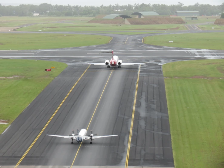 an airplane taxis down a runway that is wet
