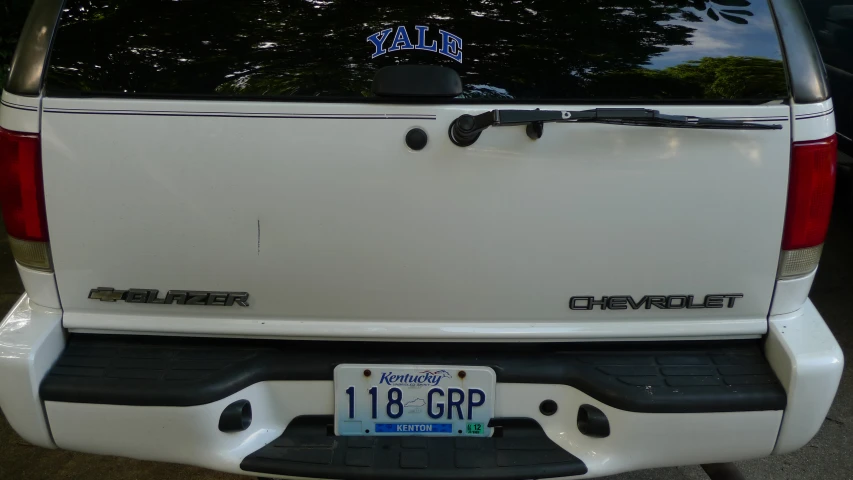 the rear end of a white truck that is parked