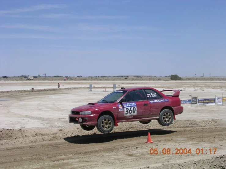 a red car driving around a race track