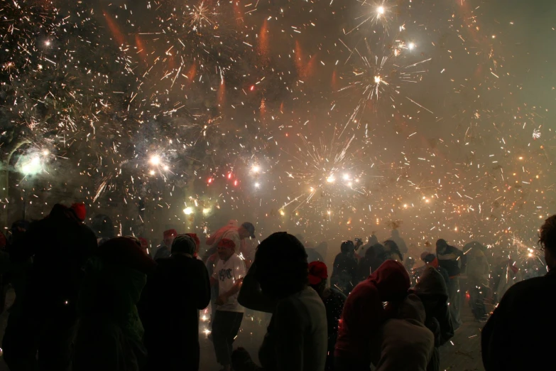 crowd of people watching fireworks from the roof of a building