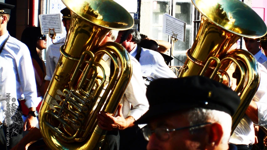 a crowd of men are standing with trombones in their hand