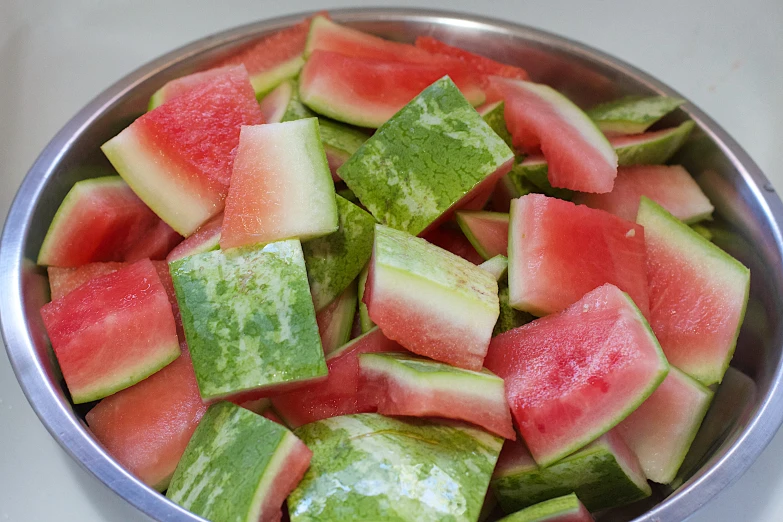 sliced pieces of watermelon in a bowl on a counter top