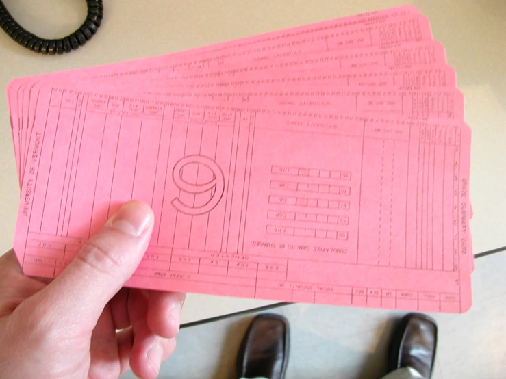 a hand holding three pink tickets with the number nine