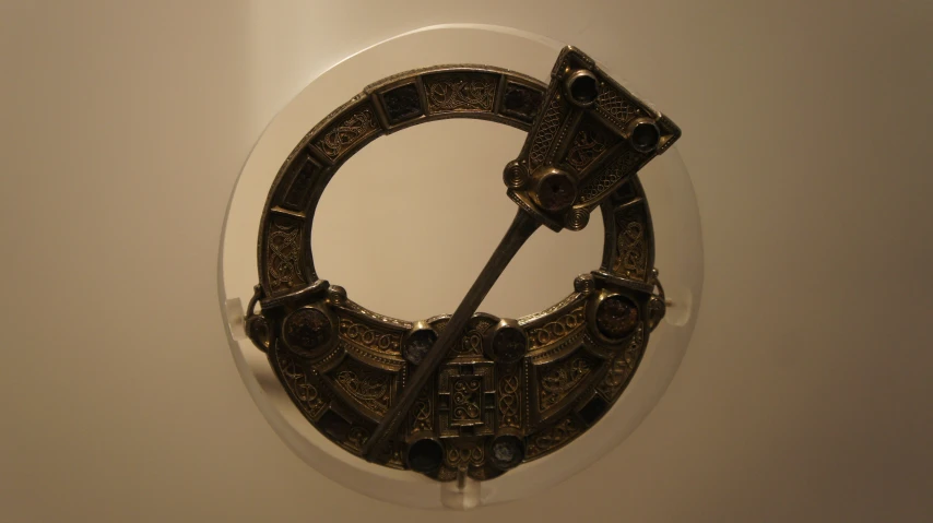 the circular mirror is displaying an elaborate metal object