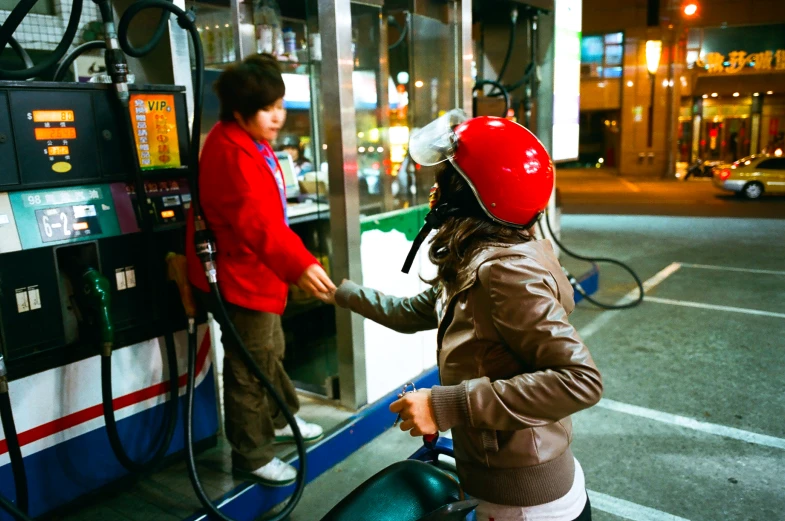 a person filling up gas at a pump