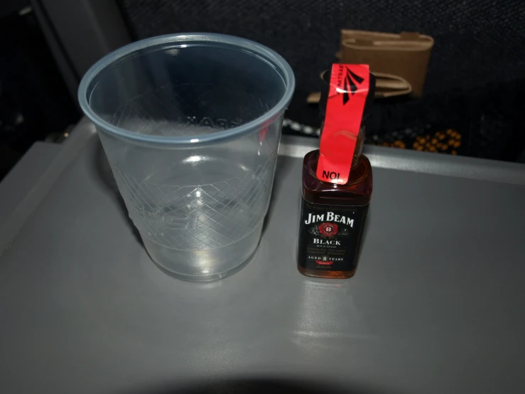 the clear cup sits on the table next to a red plastic container