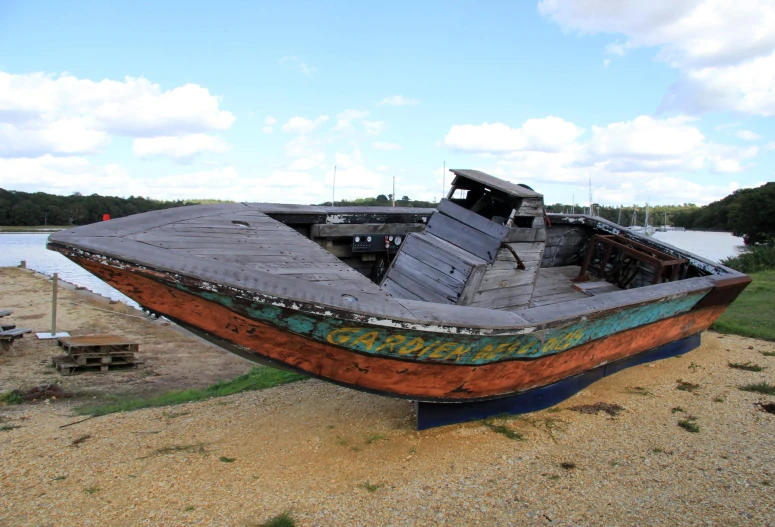 an old boat that is sitting on the beach