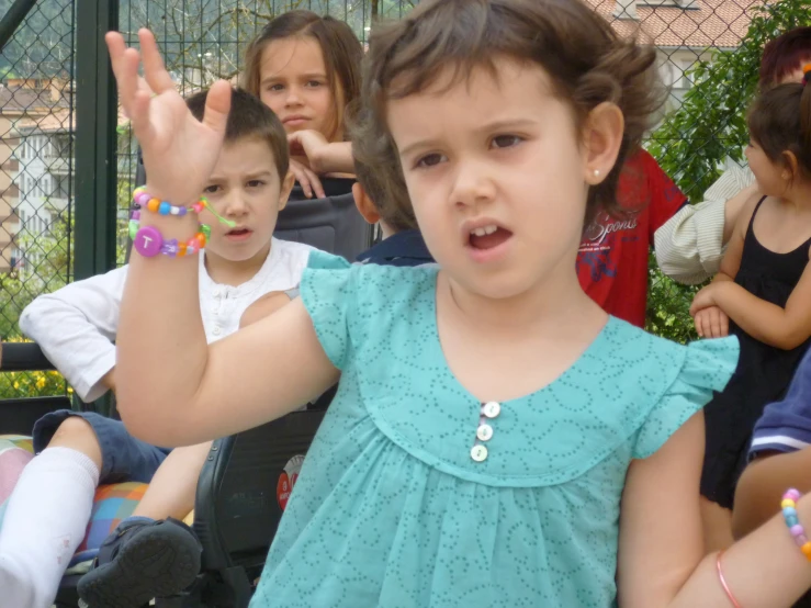 young children are holding their hand up in the air