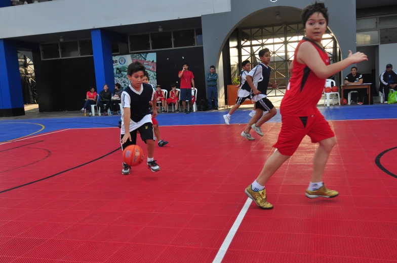 a boy playing with a ball on a court