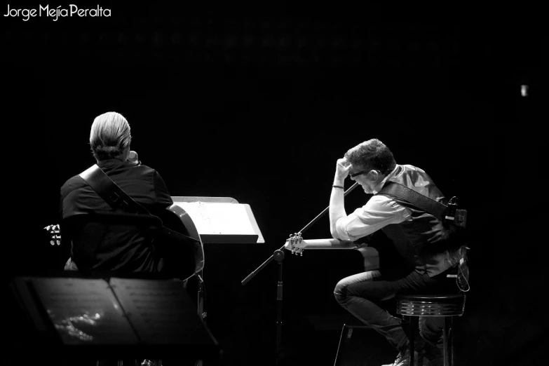 a black and white po of two people playing guitar