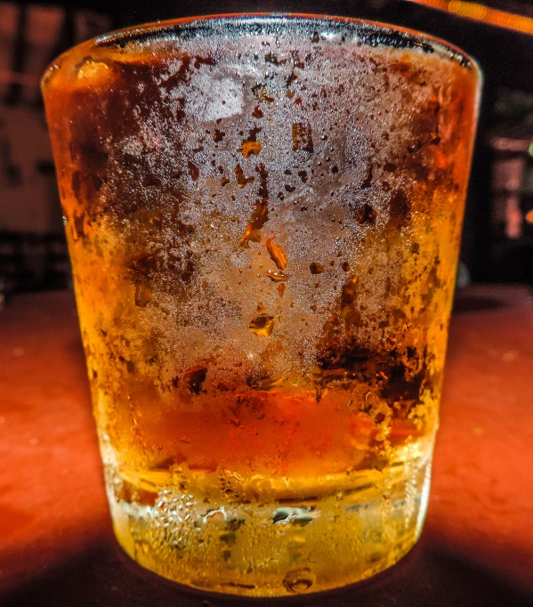 a dirty glass of alcohol on a table
