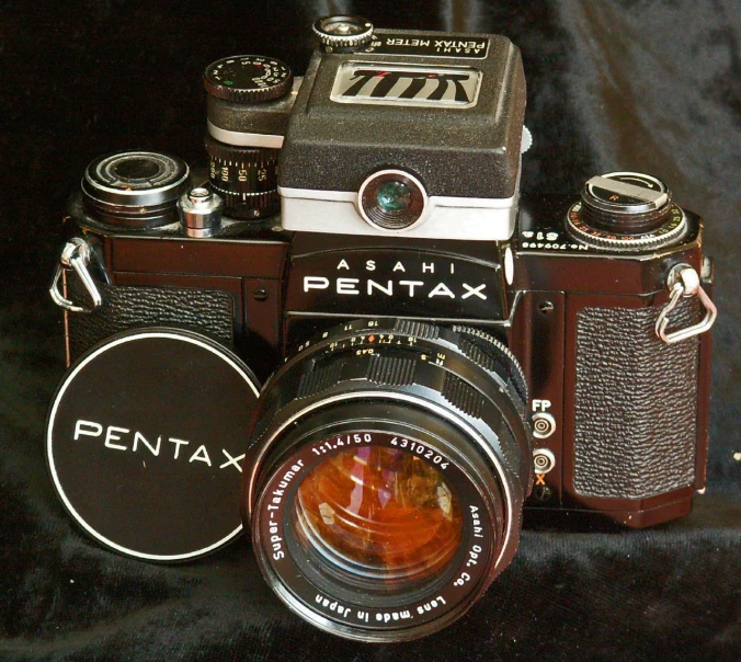 a pentax camera with a brown lens on a black background