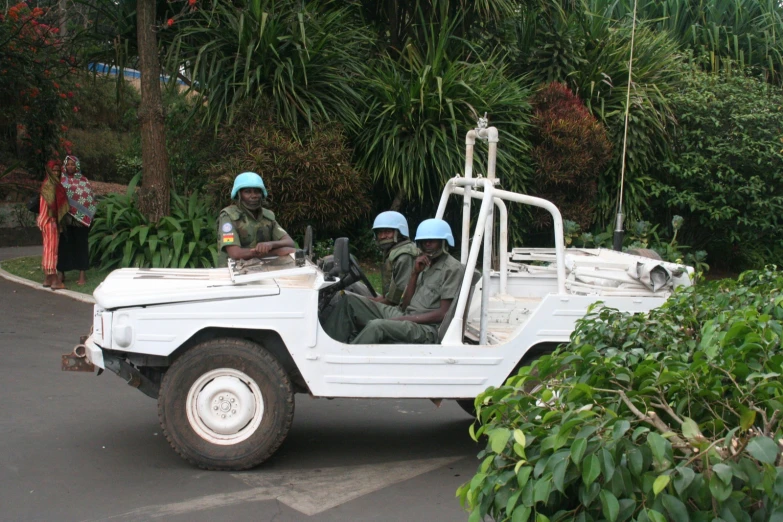 two men sitting in the driver's seat of a car with two tires