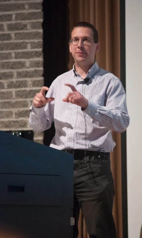 a man standing at the front of a lecture