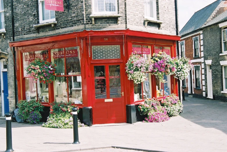 a red shop with flower boxes sitting next to it's entrance