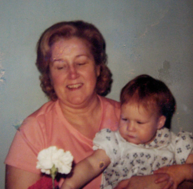 an old woman holding a baby in her arms