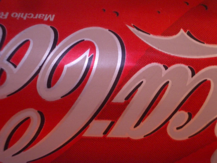 a close up of a coca - cola can with very small lettering