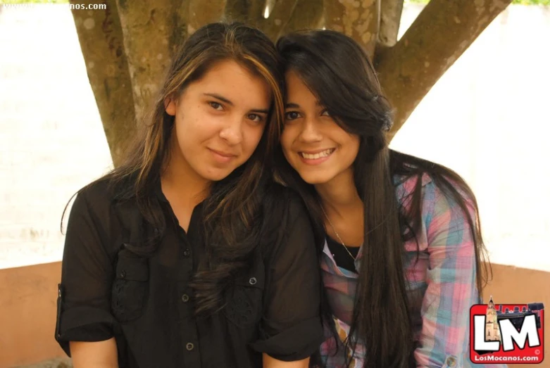 two woman are smiling and hugging each other