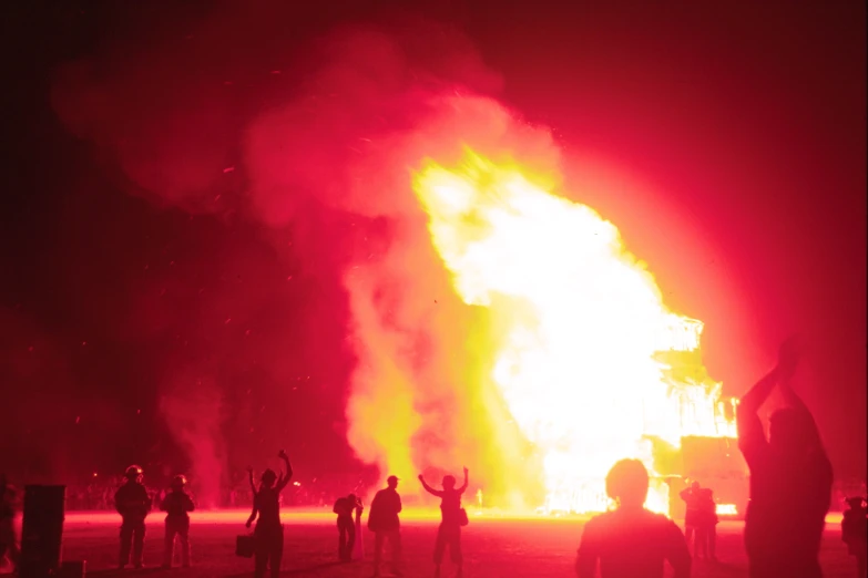 a large fire burning in the middle of a dark field