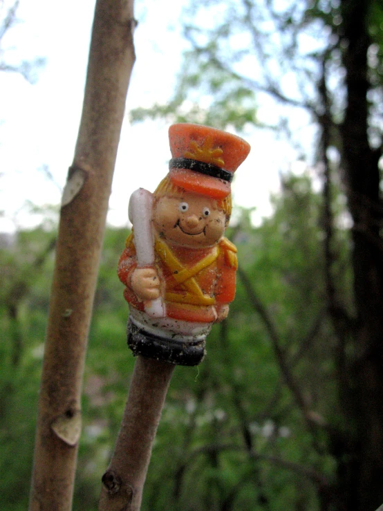 the small figurine is hanging from a tree nch