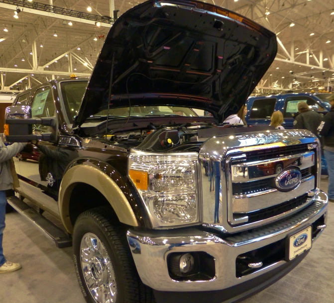 a large truck with its hood open next to people