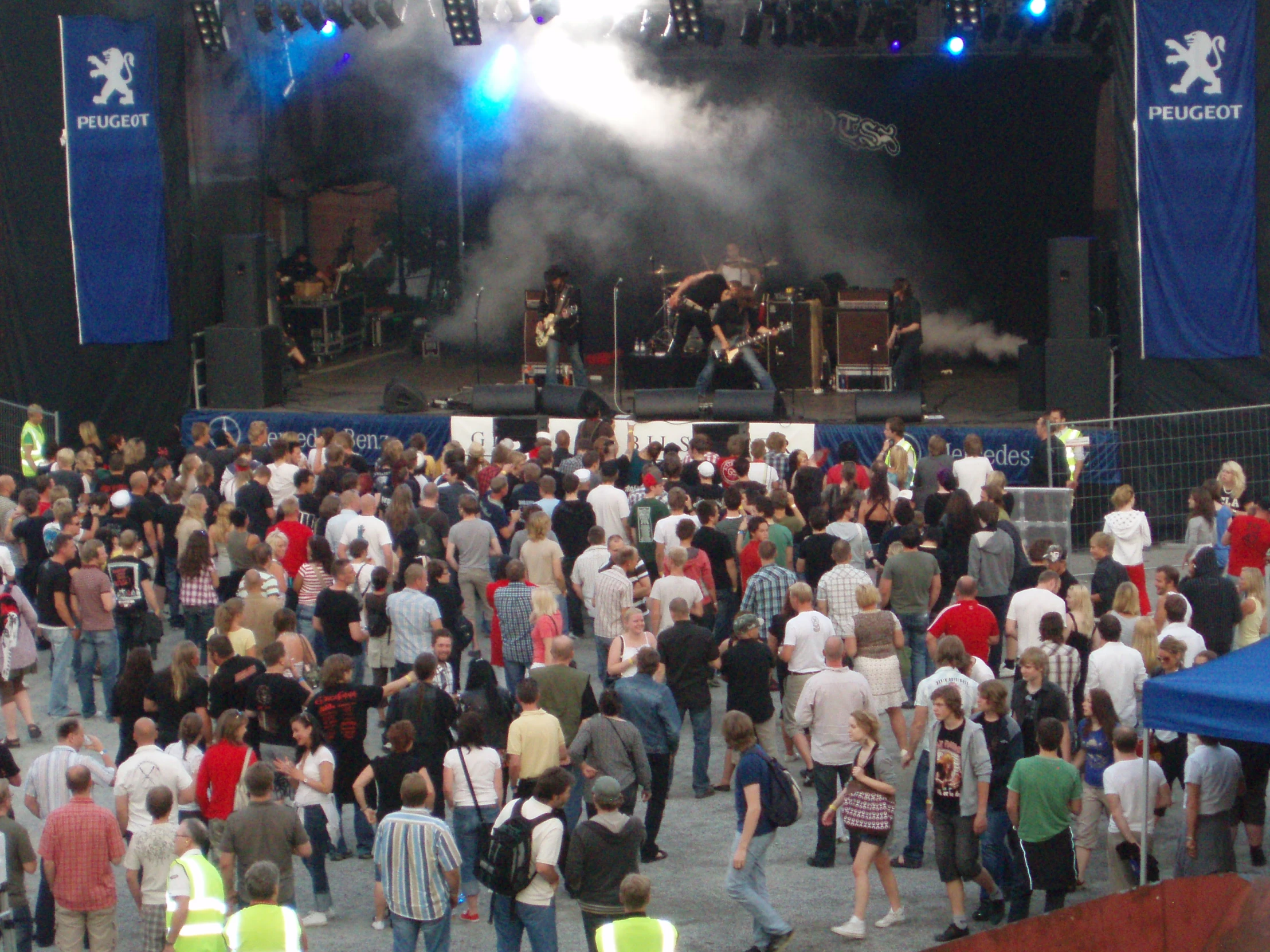 a large group of people are gathered in a large outdoor concert