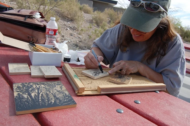 a person sitting at a table working on a piece of paper