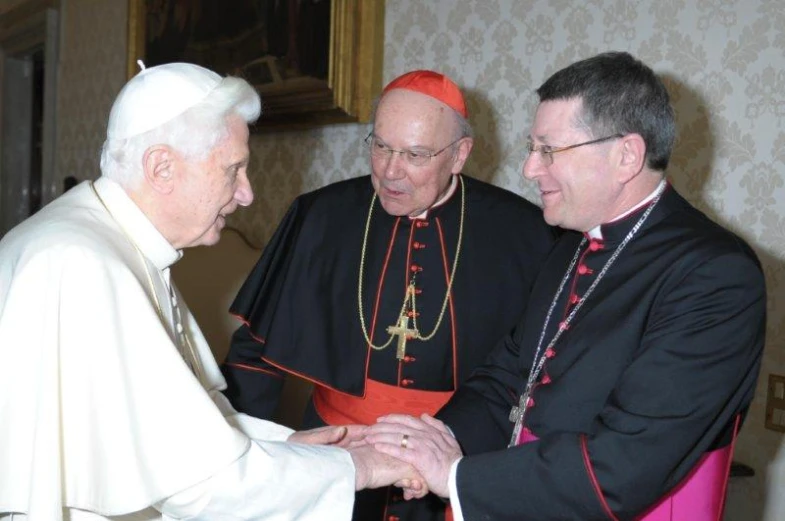 two men shake hands while two other men look on