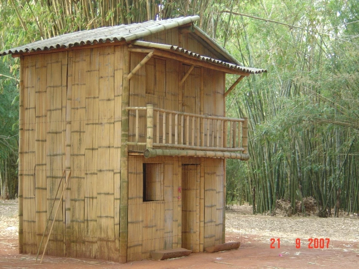 a bamboo building that is sitting in the dirt