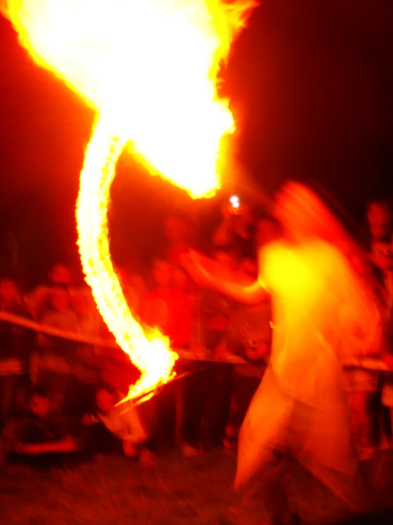 a man holding onto a fire stick on a field