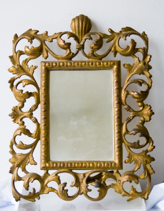 a gold frame on a white marble counter