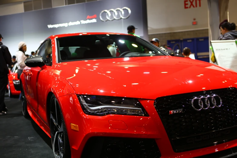 red sports car with white hood and headlights at show