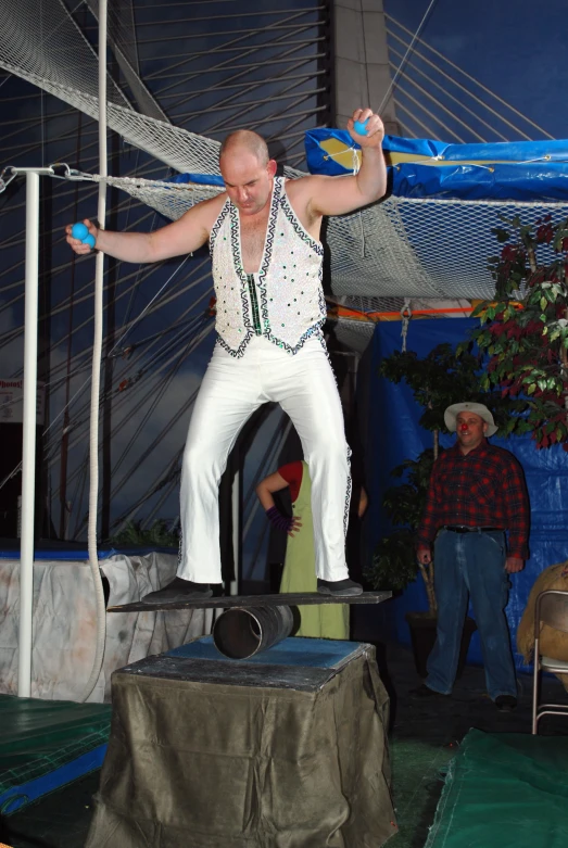 a man in white shorts and a shirt standing on a small scale