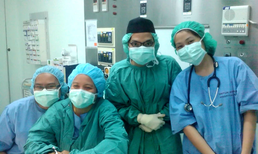 four medical personnel in scrubs pose for a picture