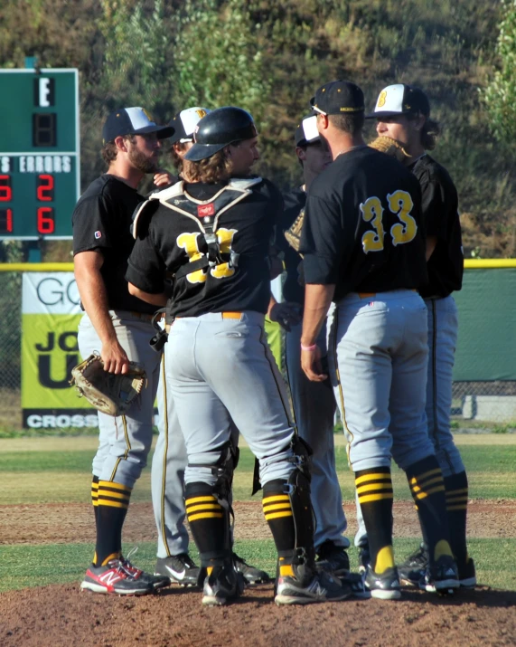 a group of baseball players are having a conversation on the field