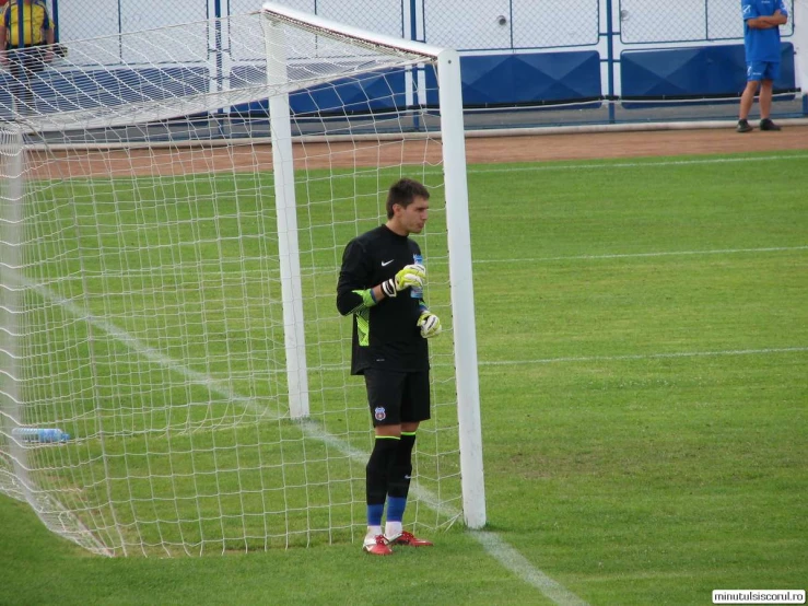 a soccer player standing next to a net