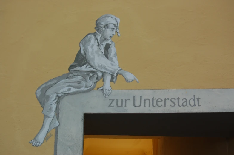 painting depicting a man sitting on a bench, the sign is painted below him