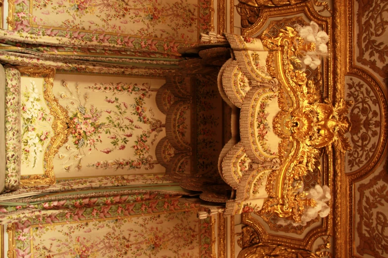 an ornate ceiling is lined with floral wallpaper