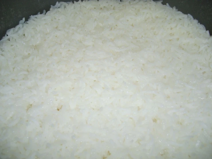 rice is cooking in a pot with a spoon